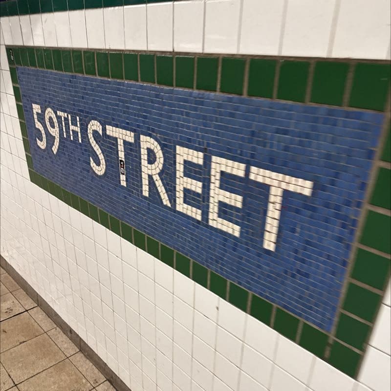 The 59th Street subway station mosaic, white letters on blue and green tile