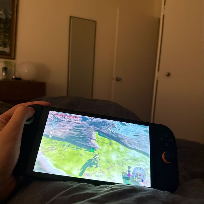 Playing Zelda on a Switch in bed by lamplight
